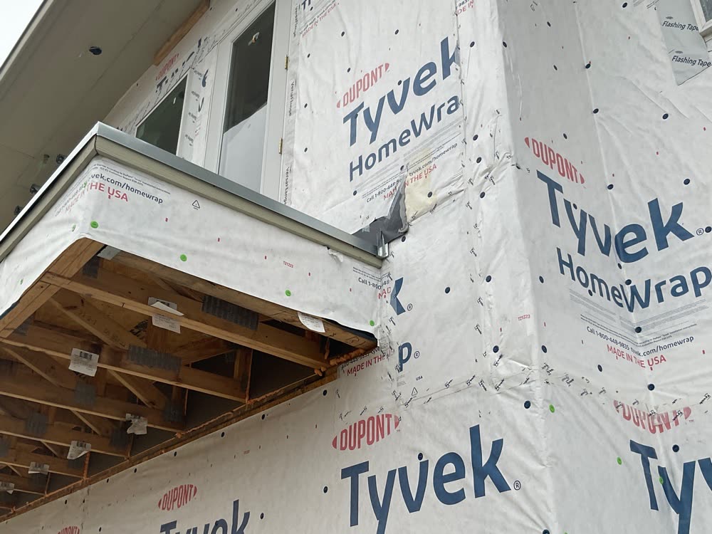 Construction site photo: balcony corner with housewrap and flashing during framing