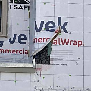 Site photo: torn house wrap exposing sheathing