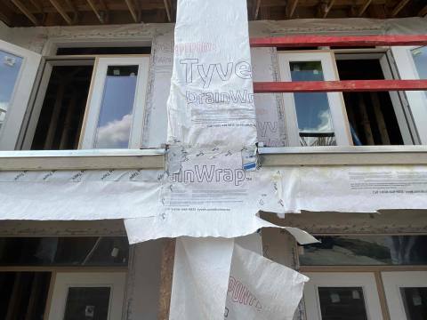 Site photo: balcony door openings with weather barrier during framing